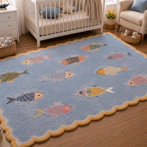 May include: A rectangular area rug with a light blue background and a scalloped yellow border. The rug features a repeating pattern of stylised fish in various colours including orange, yellow, pink, and blue, each with distinct geometric scale designs.