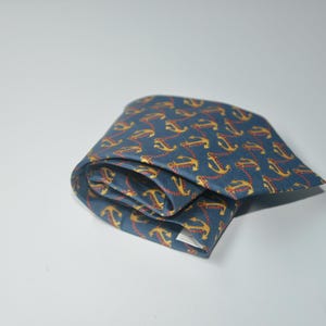 Pode incluir: Uma caneca de cer&acirc;mica branca com uma al&ccedil;a preta e o texto "But First, Coffee" em preto, com uma fonte manuscrita. A caneca est&aacute; sobre uma superf&iacute;cie branca.