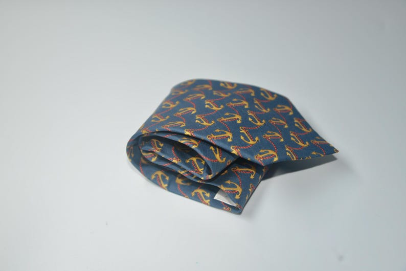 Pode incluir: Uma caneca de cer&acirc;mica branca com uma al&ccedil;a preta e o texto "But First, Coffee" em preto, com uma fonte manuscrita. A caneca est&aacute; sobre uma superf&iacute;cie branca.