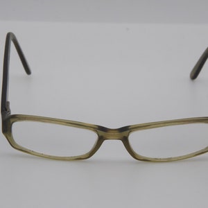 May include: A pair of tortoiseshell eyeglasses with a rectangular frame and clear lenses.
