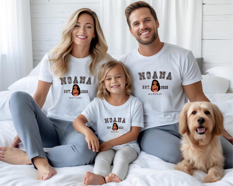Pu&ograve; includere: Una famiglia indossa magliette bianche abbinate con la parola "MOANA" in un font universitario. Le magliette presentano anche una grafica di una donna e il testo "EST. 2018 MOTUNUI". Un cane golden retriever &egrave; anche nell'immagine.