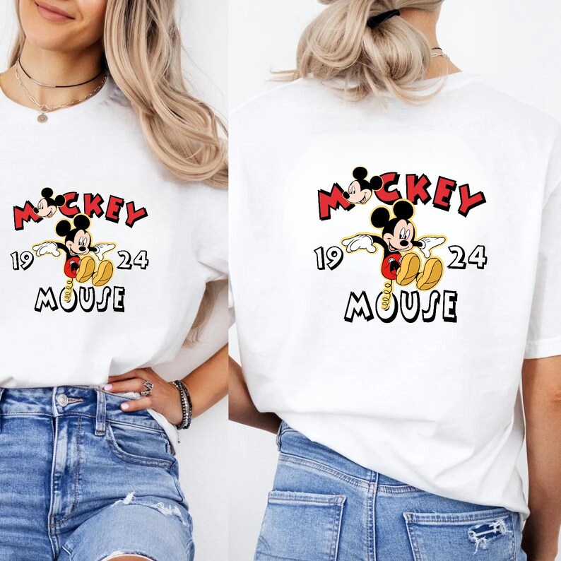 May include: White t-shirt with a Mickey Mouse graphic. The design includes the word "Mickey" in red, the numbers "19" and "24", and the word "Mouse" in black. The graphic is on the front and back of the shirt.