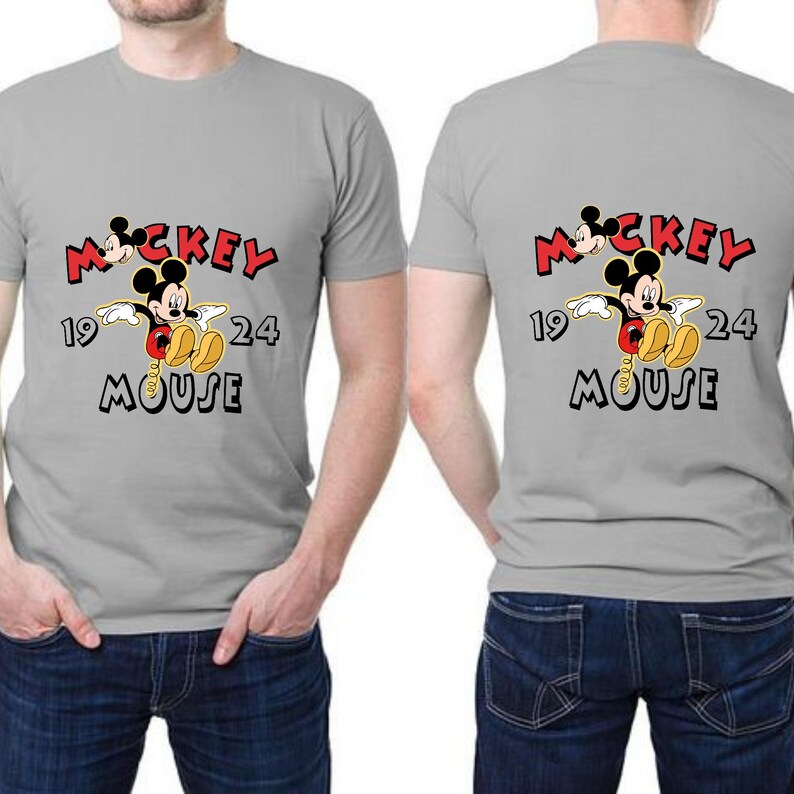 May include: Grey t-shirt with a Mickey Mouse design on the front and back. The graphic includes the word "Mickey" in red, the number "1924", and the word "Mouse" in black. The shirt is made of a soft material.