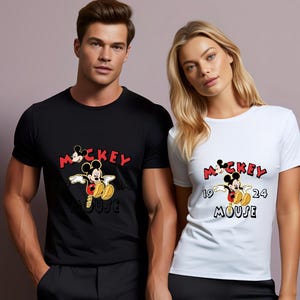 May include: Black and white t-shirts with a Mickey Mouse graphic. The design includes the word "Mickey" in red, the year "1924", and the word "Mouse". The shirts are short-sleeved.