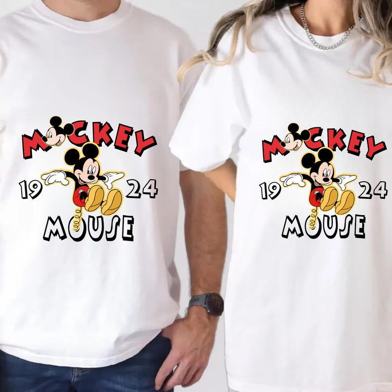 May include: White t-shirts with a Mickey Mouse graphic. The design features the word "Mickey" in red, the numbers "19" and "24", and the word "Mouse" in black. Mickey Mouse is shown in his classic pose.