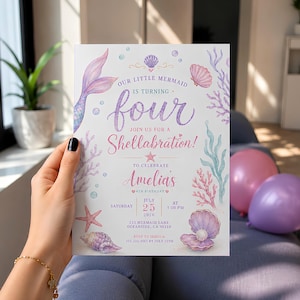 May include: A rectangular birthday invitation card featuring a mermaid tail, seashells, and coral illustrations in pastel purple, pink, and blue. The text reads: Our Little Mermaid is turning four, join us for a Shellabration, Amelia's 4th birthday, July 25, 2026.