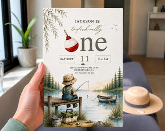 May include: A rectangular birthday invitation card featuring a watercolor illustration of a child fishing on a wooden dock. The text reads: JACKSON IS O-fish-ally one, SAT SEPT 11, 2-4 PM, 210 MINNOW POND LANE, BOBBERVILLE, FL, RSVP TO JOHN 123-525-1234.