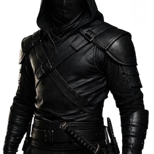 Può includere: Una persona in un completo nero con cappuccio, maschera facciale, armatura in pelle e una spada. Il costume include spalline, protezioni per le braccia e una cintura. L'estetica generale è oscura e furtiva.