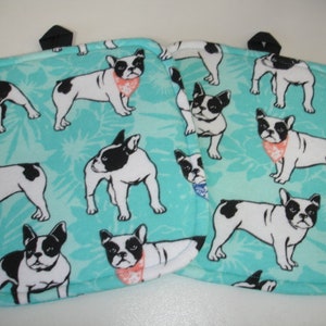 May include: Two turquoise blue fabric pot holders with a white border and a repeating pattern of black and white French Bulldogs wearing colorful bandanas.