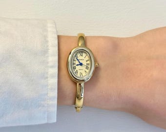 Reloj brazalete de oro para mujer con números romanos y cuarzo.
