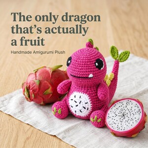 May include: A handmade amigurumi plush dragon in bright pink, with a white belly and black eyes, sits next to a whole and a halved dragon fruit. The text reads: "The only dragon that's actually a fruit."