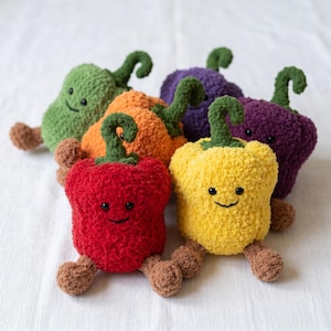 Puede incluir: Colección de pimientos de peluche hechos a mano en varios colores: rojo, amarillo, naranja, verde y morado. Cada pimiento tiene una cara sonriente, patas marrones y un tallo verde. Estos juguetes blandos son ideales para una habitación infantil.