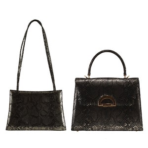 Op de afbeelding: Twee zwarte handtassen van slangenleer met gouden hardware. De ene handtas heeft een bovenste handvat en de andere een schouderband.