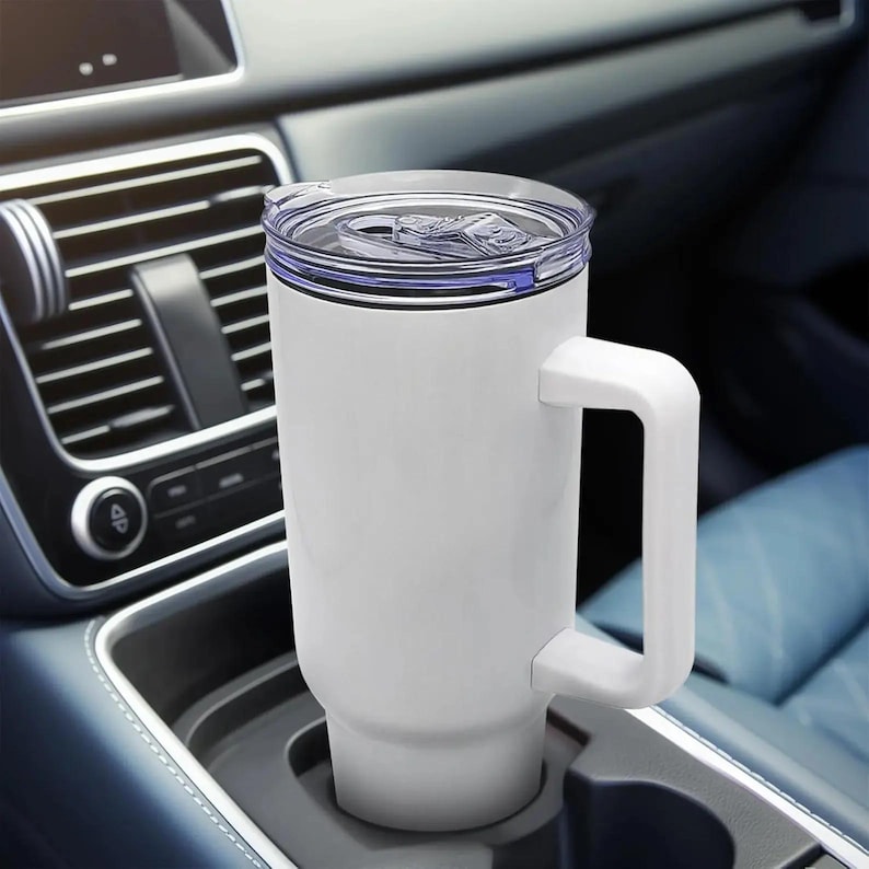 Puede incluir: Un termo de viaje blanco con asa y tapa transparente. El termo es cil&iacute;ndrico y cabe en el portavasos de un coche. La tapa tiene un cierre deslizante. El termo est&aacute; dise&ntilde;ado para mantener las bebidas calientes o fr&iacute;as.