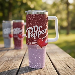 Puede incluir: Un vaso de acero inoxidable con asa y tapa blancas. El vaso presenta el logotipo de Dr Pepper con un coraz&oacute;n y la frase "Is my". El vaso tiene una parte superior burdeos y una inferior lavanda con motas blancas.