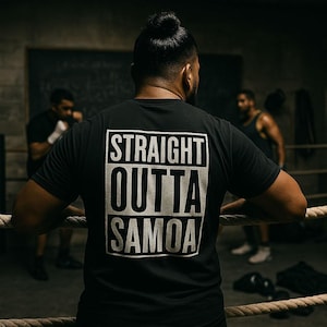May include: Black t-shirt with the text "STRAIGHT OUTTA SAMOA" in a white, rectangular design. The shirt is worn by a person in a boxing ring, with other people in the background. The scene is set in a dimly lit gym.