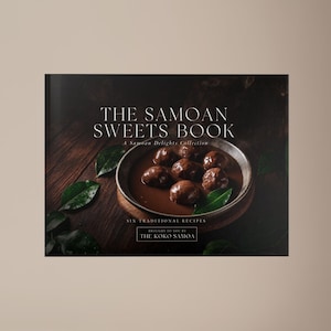 Op de afbeelding: Een kookboek getiteld "The Samoan Sweets Book" met een donkere omslag. De omslag toont een kom met chocoladedesserts en de tekst "A Samoan Delights Collection". Het boek ligt op een houten oppervlak met groene bladeren.