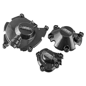 May include: Three carbon fiber motorcycle engine covers. The covers are black with a woven pattern and the text "HPR" is visible on each cover. The covers have multiple mounting holes.