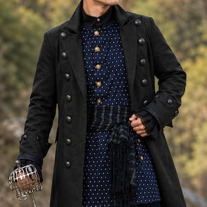 Peut inclure: Un long manteau noir à boutons dorés croisés porté sur une chemise bleu foncé à motif géométrique blanc. Une écharpe bleu foncé à franges est nouée à la taille. Une garde d'épée en métal avec une protection en cage est tenue à la main.