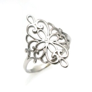 K&ouml;nnte beinhalten: Ein silberner Ring mit einem filigranen, komplizierten Design, das an eine Blume oder eine Schneeflocke erinnert. Der Ring besteht aus einem d&uuml;nnen Band und hat ein gro&szlig;es, durchbrochenes Design.