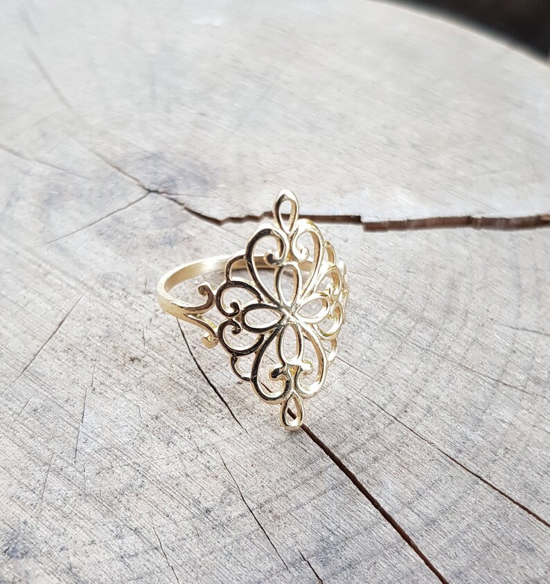 K&ouml;nnte beinhalten: Ein goldener Filigranring mit einem zarten, filigranen Design. Der Ring ist diamantf&ouml;rmig und hat ein florales Muster.