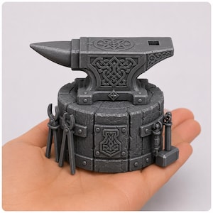 May include: A miniature gray anvil with intricate Celtic knotwork and a hammer, tongs, and other blacksmith tools. The anvil sits on a wooden base. The overall design is reminiscent of Norse mythology.