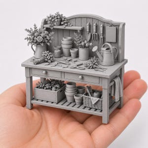 May include: A miniature grey potting bench featuring a wooden structure with two drawers, a lower shelf, and a backboard. The surface holds small flower pots, a watering can, gardening tools, a basket, a crate of plants, and floral arrangements.