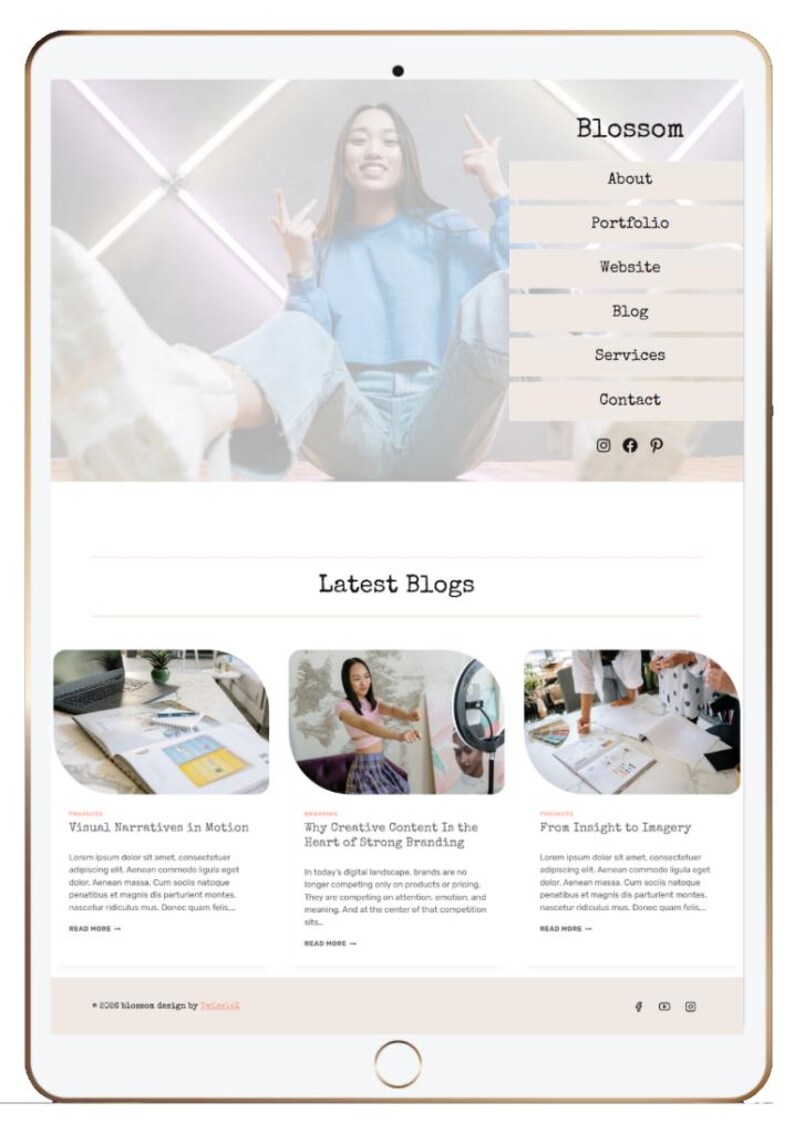 May include: A digital tablet displays a website interface with the name "Blossom" at the top. The site features navigation links and blog previews. A person is visible in the background.
