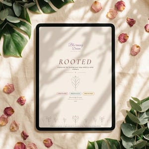May include: A digital planner on a tablet with the title "ROOTED" and the text "A planner for finding your way back to what matters." The image is surrounded by greenery and dried rose petals.