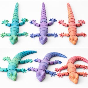 May include: Six articulated lizard toys in a variety of colors, including blue, green, purple, and orange. Each lizard has a segmented body and outstretched limbs, creating a playful and colorful display. These toys are suitable for children.