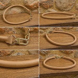 Pu&ograve; includere: Un manico per borsa tubolare e arrotondato di colore beige con finiture in metallo dorato. Il manico &egrave; realizzato in un materiale liscio a tinta unita e include chiusure a moschettone dorate lucide su ciascuna estremit&agrave; per l'aggancio.