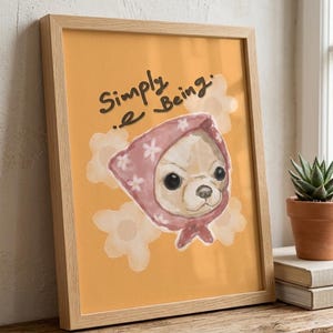 以下が含まれることがあります： ピンク色のスカーフを被った犬の水彩イラストが描かれた、額入りのアートプリント。オレンジ色の背景に「Simply Being」という文字が黒い筆記体で書かれています。フレームは明るい木製です。