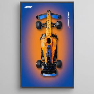 以下が含まれることがあります： マクラーレンF1レーシングカーの俯瞰図がフレームに入った画像。車体はオレンジとブルーを基調とし、背景はブルーとオレンジのグラデーション。マクラーレンのロゴが見える。