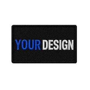 Op de afbeelding: Een rechthoekige, zwarte geborduurde patch met de tekst "YOUR DESIGN" in wit en blauw. Deze patch is ontworpen voor personalisatie, waardoor gepersonaliseerde ontwerpen kunnen worden toegevoegd aan kleding of accessoires.