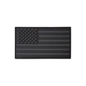 May include: A rectangular morale patch featuring a monochromatic black and dark gray American flag design. The patch displays a raised, textured canton with stars and horizontal stripes, constructed from a durable, molded rubberized material.