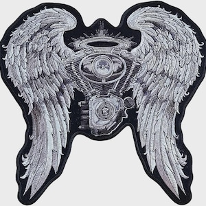 Puede incluir: Parche bordado con un diseño de motor de motocicleta con alas de ángel. El parche es principalmente negro y plateado, con costuras detalladas que crean una apariencia texturizada. Las alas están extendidas y un halo se encuentra sobre el motor.