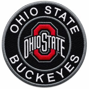 Può includere: Toppa circolare nera con testo ricamato bianco che recita "OHIO STATE BUCKEYES". Il centro presenta un logo "O" rosso con "OHIO STATE" in bianco. La toppa ha un bordo grigio.