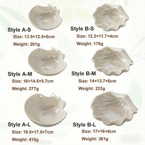 May include: A collection of six off-white seashell-shaped ceramic dishes. Each dish is labeled with a style designation and size in centimeters, along with its weight in grams. The sizes range from 12.2cm x 11.7cm x 4cm to 18.5cm x 17.5cm x 7cm.