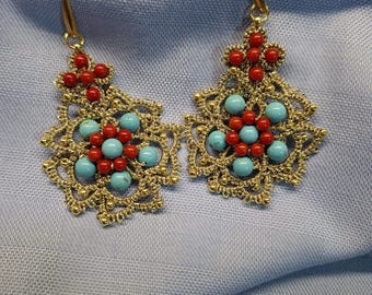 Pendientes colgantes con piedras naturales de coral de bambú rojo y aulita turquesa sobre encaje de bolillos. Hechos a mano.