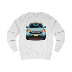 May include: White sweatshirt featuring a stylized illustration of a blue and yellow SUV. The car has yellow headlights and a yellow license plate. The design is centered on the front of the sweatshirt.