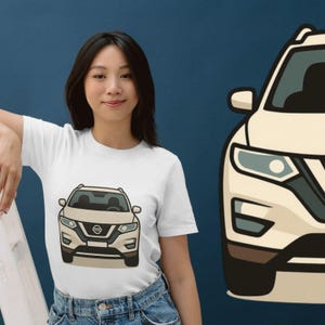 May include: A white short-sleeve t-shirt featuring a graphic illustration of a beige Nissan SUV on the front. The graphic depicts the front view of the vehicle with headlights, a grille, and the Nissan logo clearly visible in a flat, stylized design.