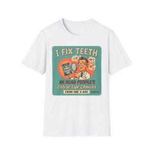 May include: White t-shirt with a retro graphic. The design states "I FIX TEETH AND READ PEOPLE'S ENTIRE LIFE CHOICES FROM ONE X-RAY." The graphic shows a dentist with a mirror and an X-ray image, in a vintage style.