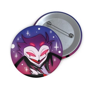 May include: A round button pin featuring a cartoon character with a purple and red color scheme. The character has red eyes and a smiling expression. The background is a gradient of purple and pink with white stars.