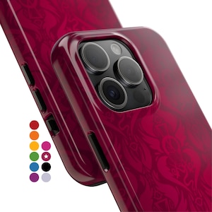 May include: A deep magenta smartphone case featuring a repeating ornate pattern, shown from the back to reveal the camera lens array and side buttons. A vertical column of small colored circles is displayed to the left, indicating color options.