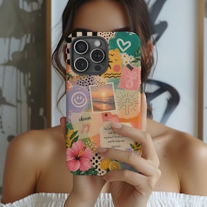 May include: A patterned phone case with a collage design, including a smiley face, a sunset image, a cross, and a pink hibiscus flower. The case features the words "choose joy" and a Bible verse. The top left corner has a black and white checkered pattern.