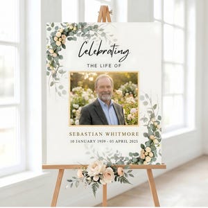以下が含まれることがあります： 木製のイーゼルに立てられた追悼のサイン。 金色のフレームに入った男性の写真、テキスト「Celebrating the Life of」、男性の名前と日付が表示されています。 花と緑のアクセントで飾られており、葬儀や追悼に最適です。