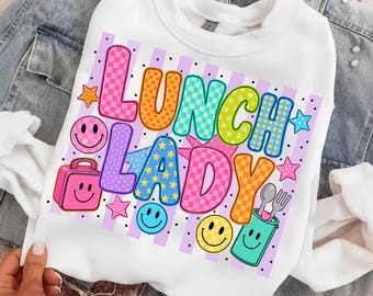May include: A white crewneck sweatshirt featuring the text LUNCH LADY in colorful, patterned bubble letters. The design includes pink, orange, teal, green, and blue graphics of smiley faces, a lunch box, a utensil cup, and stars on a striped background.