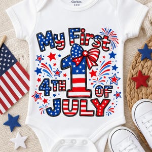 May include: A white short-sleeved bodysuit featuring a graphic with the text My First 4th of July. The design includes a large number one with a red, white, and blue star-spangled pattern, a patriotic bow, and surrounding firework and star motifs.