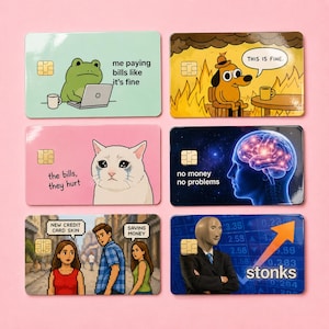 May include: Set of six credit card skins with humorous meme designs. Includes a frog with a laptop, a dog in a burning room, a crying cat, a brain, a couple, and a businessman with the word "stonks".