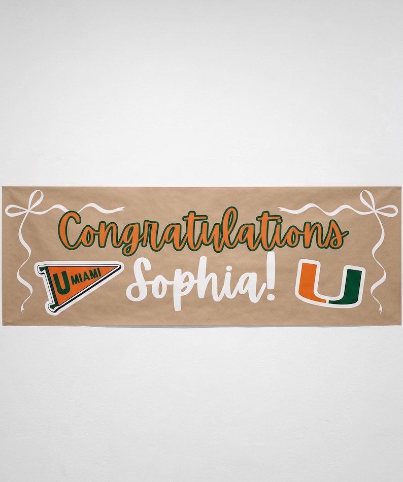 May include: A brown banner with the words "Congratulations Sophia!" in white and orange script. The banner includes the University of Miami logo and decorative white ribbons.